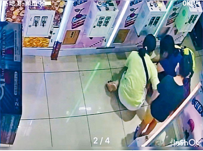 兩女子把貓店長GetGet推進手拉車的袋，男童在旁觀看。
　　