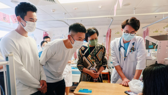 林新栋（左一）及王玮骏（左二）到访玛嘉烈医院，期间与儿科病童倾谈，祝愿他们早日康复。政府新闻处图片
