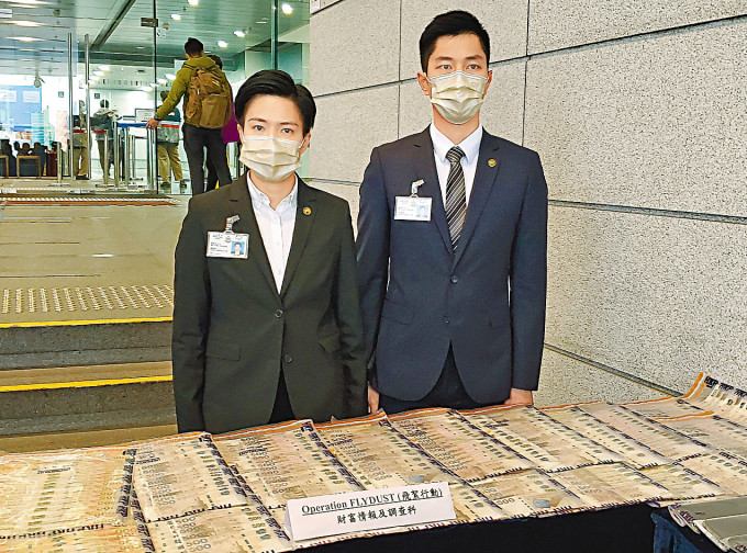 总督察邓凯彤（左）及高级督察杨展荣（右）展示检获的现钞等证物。
