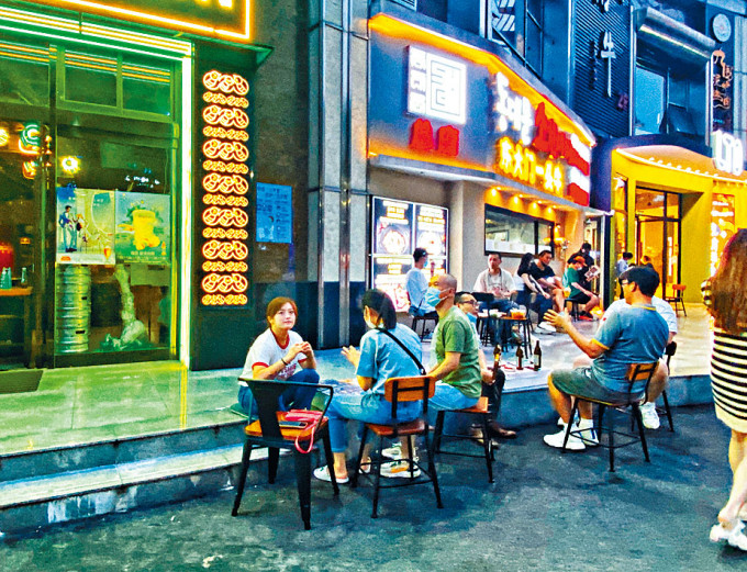 上海一餐厅门外，坐满买外卖的顾客。