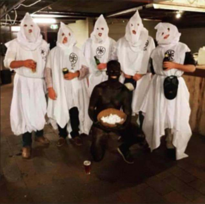 其中一張照片所見，5名學生戴上頭巾、身穿白色三K黨罩袍，站在一名全身塗黑的男子身後。