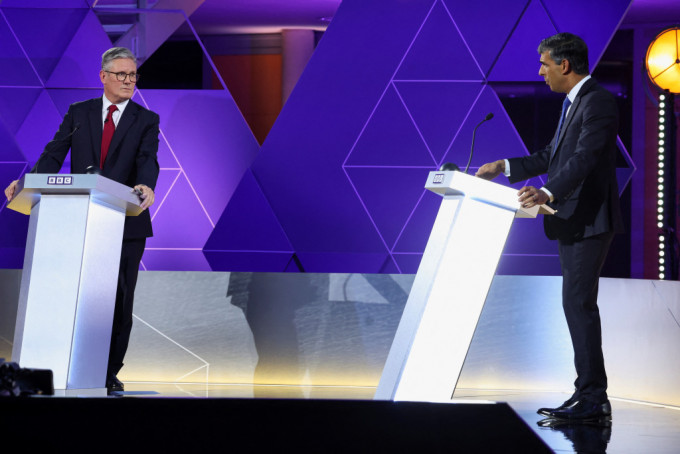 在英国大选前最后电视辩论中，辛伟诚（右）与施纪贤激烈交锋。路透社
