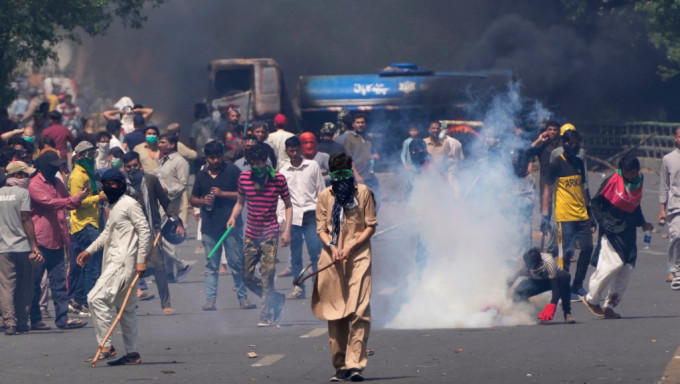 伊姆蘭汗被捕引發各地示威並釀成暴力衝突，圖為拉合爾警方以催激彈驅散人群。 美聯社