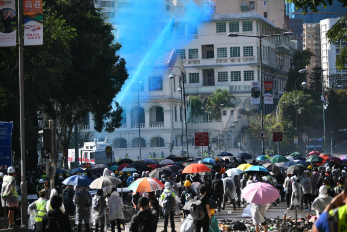 水炮車射出藍色水驅散。