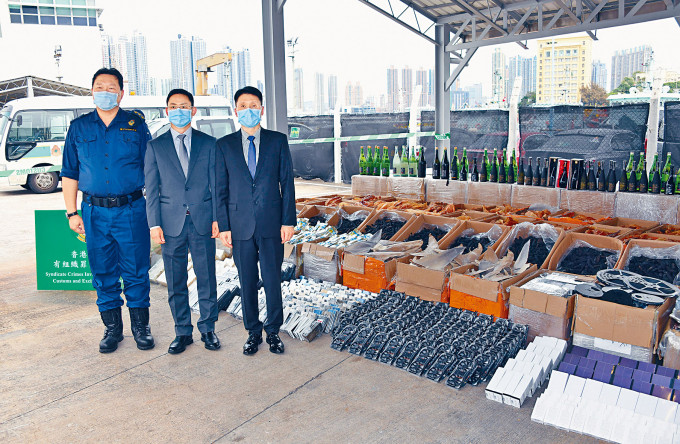 ■（由右至左）海關官員胡偉軍、鄭德榮及黃雅綸展示截獲的大批走私貨品。