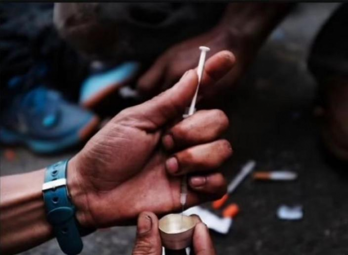 圖為紐約街頭的吸毒者使用簡陋的工具注射毒品。