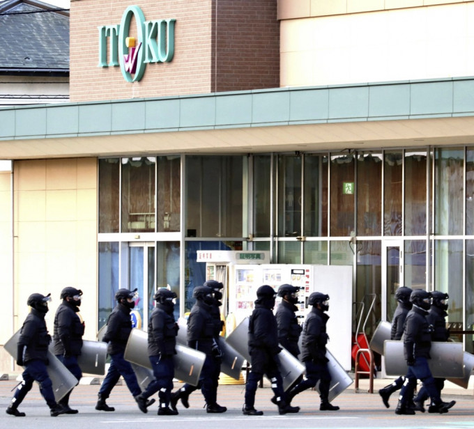 秋田市超市土崎港分店遭熊入侵，警方手持盾牌严阵以待。美联社