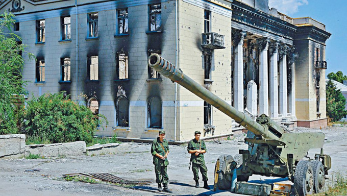 在烏東盧甘斯克地區的利西昌斯克市，一些親俄武裝人員七月站在烏軍撤離後留下的榴彈炮旁。