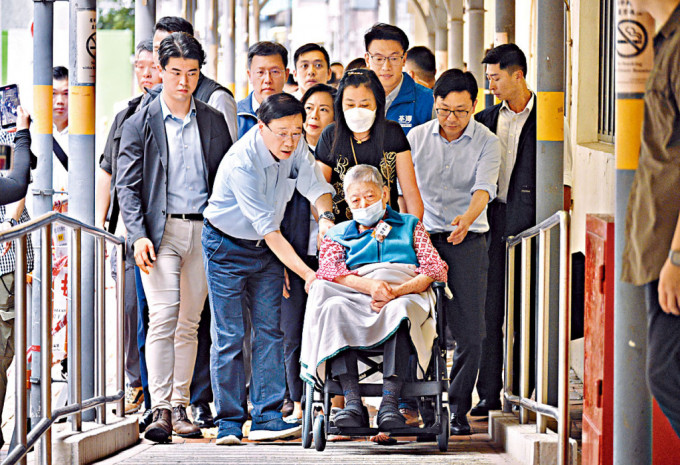 李家超昨日探访患有认知障碍的长者，并亲自送一名须坐轮椅的长者返回屋邨。