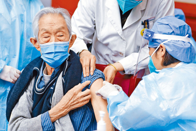 醫護人員為九十四歲的老人接種新冠疫苗。