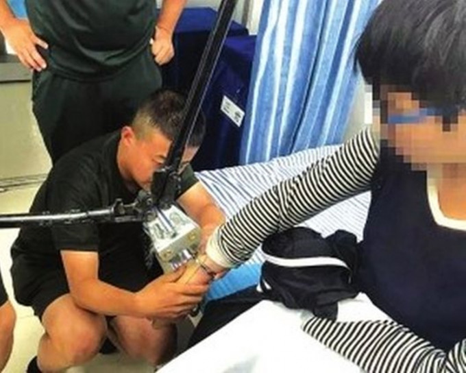 少年在警方和消防員的幫助下剪除手銬。網圖