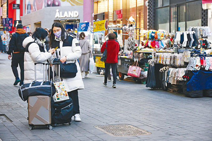中国旅客在明洞购物区流连。