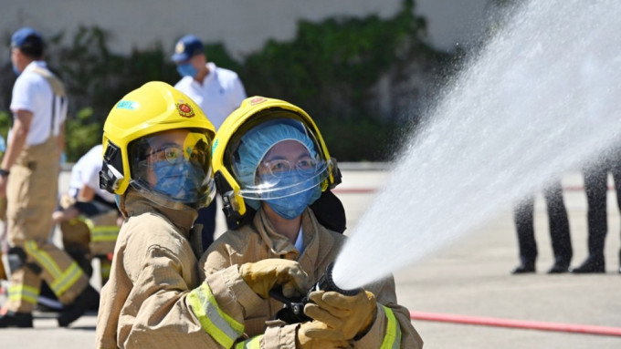 团员穿上灭火防护服，模拟消防员于火场灌救。政府图片