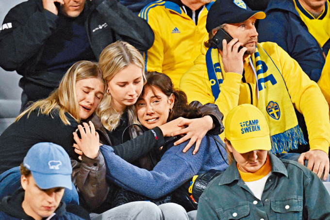 在布魯塞爾的球場內，瑞典球迷得悉發生槍擊命案後表現哀傷。