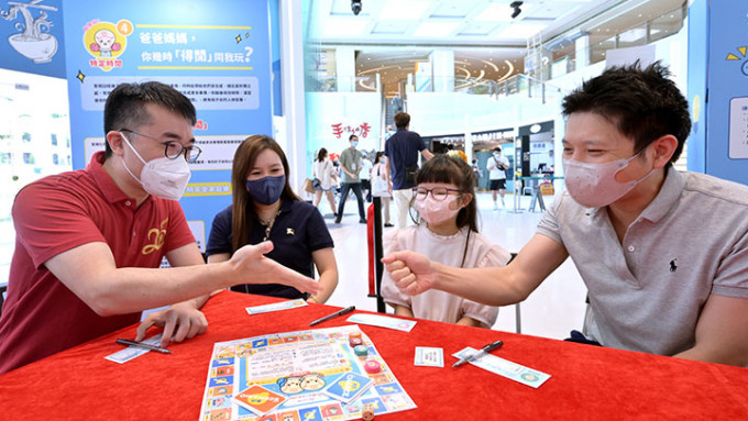 施俊輝（左一）與家長和小朋友試玩「玩轉親子樂」親子桌上遊戲。