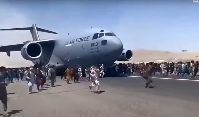 大批絕望的阿富汗人試圖攀附上美軍運輸機。網上圖片