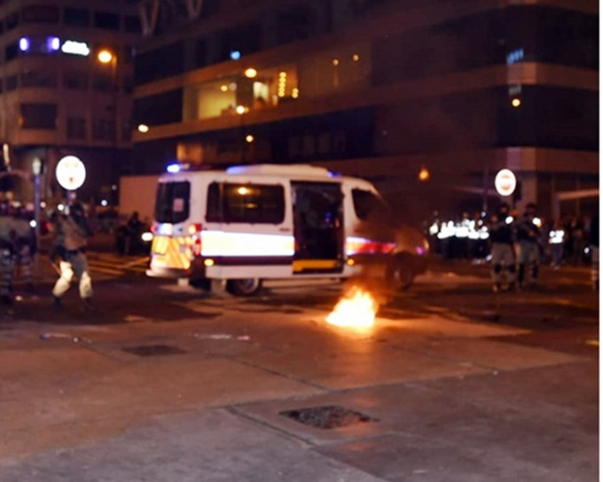 示威者在亚皆老街向警车方向投掷汽油弹。