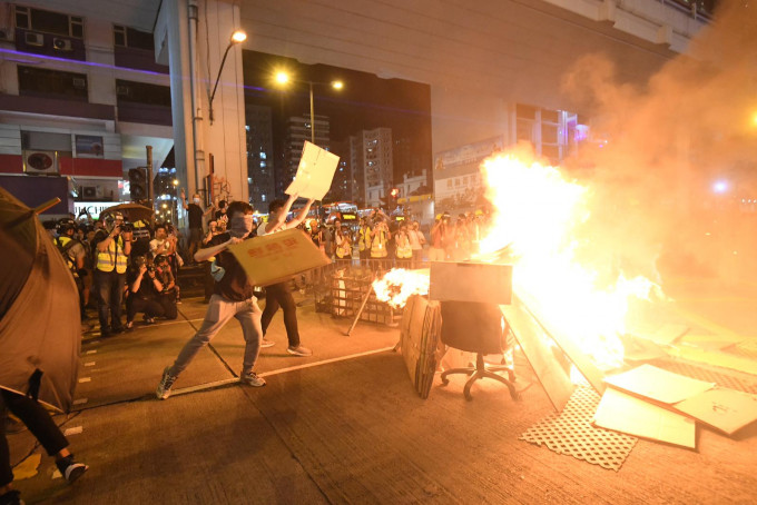 示威者不断将杂物掷向火堆。