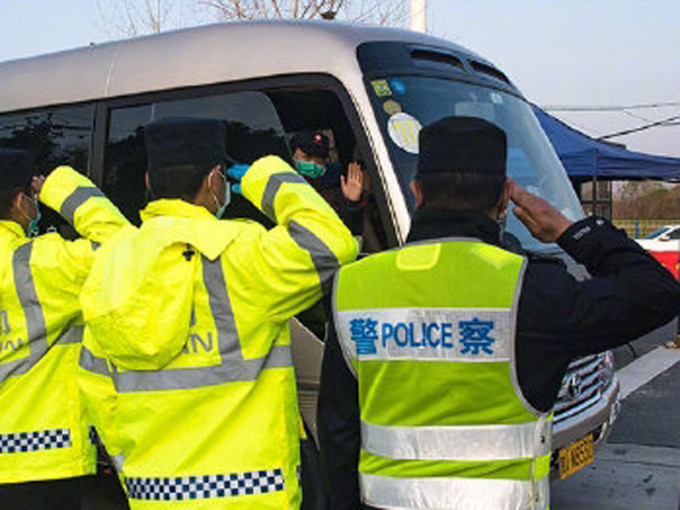 关卡执勤警员列队敬礼，目送陕西国家紧急医学救援队离开。(新华社)