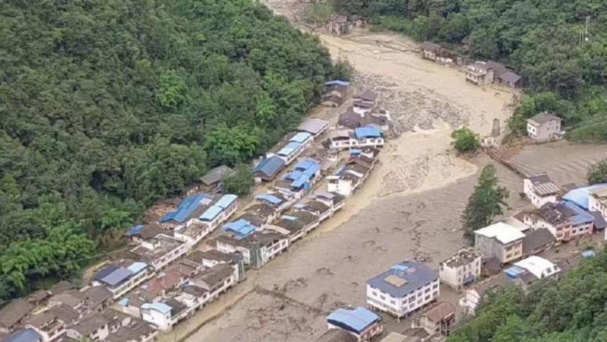 洪水夹杂漂浮物及泥土冲进城镇。新华社