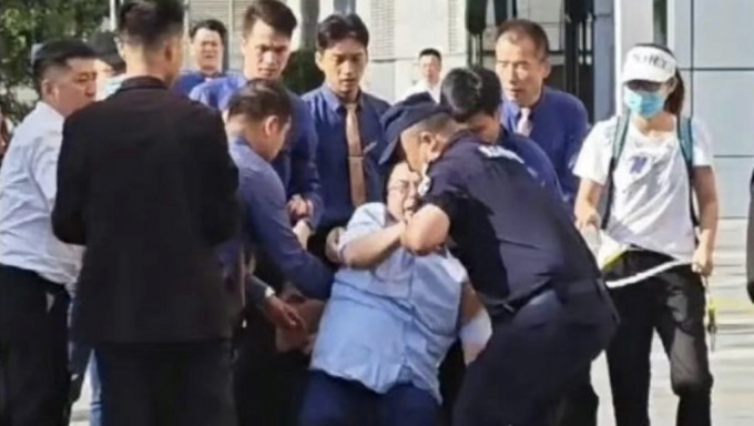 遭讨薪者围殴的宝能集团董事长姚振华跌倒在地。网上图片