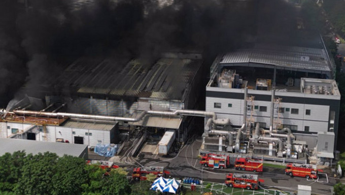 屏东科技产业园区明扬高球厂22日发生爆炸，火场23日持续闷烧，浓烟更加浓烈，一旁的厂房岌岌可危，多部消防车灌水降温。中时