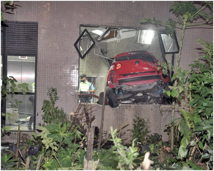 紅色私家車撞爆玻璃插入工廈梯間。