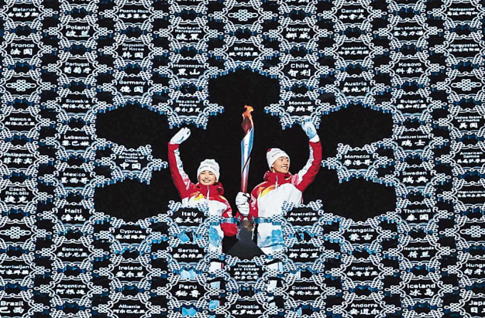 維族選手迪妮格爾（左）和趙嘉文將火炬嵌入「大雪花」中央。
