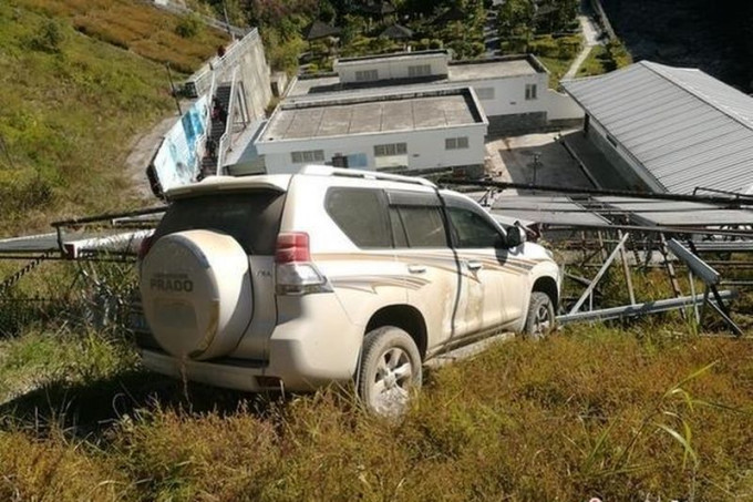 车辆冲入山坡后被太阳能热水器支架卡住。图腾讯