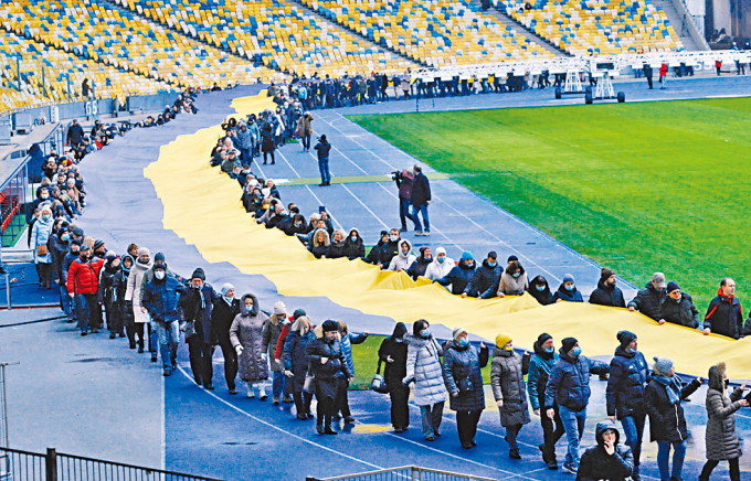 烏克蘭基輔的民眾周三響應「團結日」，在體育館拉開巨大國旗。