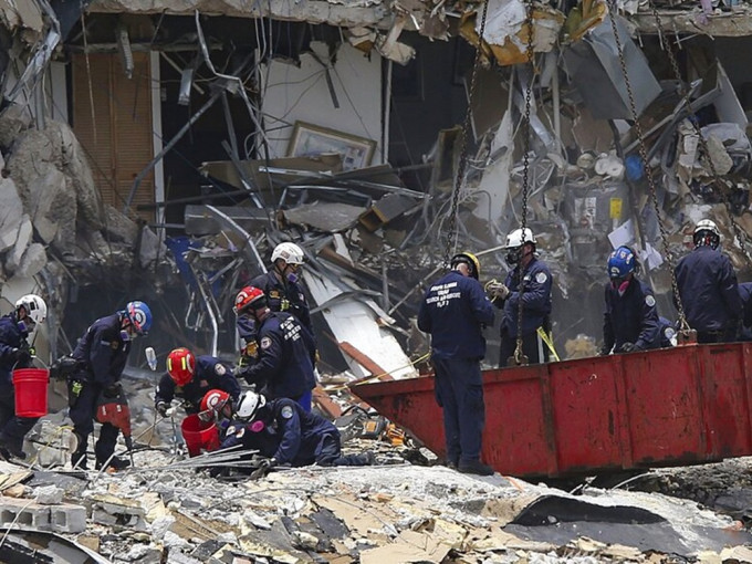 救援人员继续在塌楼现场搜寻失踪者。AP图