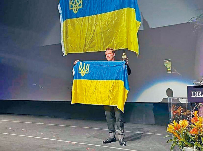 班尼狄在電影節上拉起烏克蘭國旗表態。
