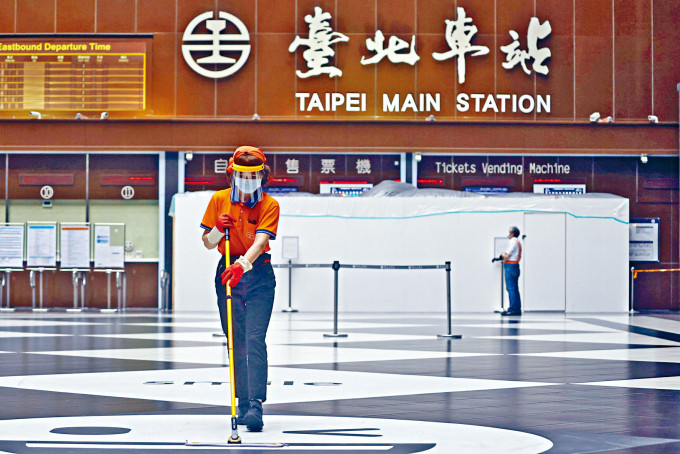 戴着防疫面罩的台北车站清洁人员。