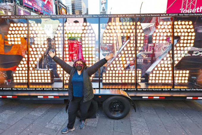■一名女子在紐約時代廣場與「2022」字樣燈牌合照。 