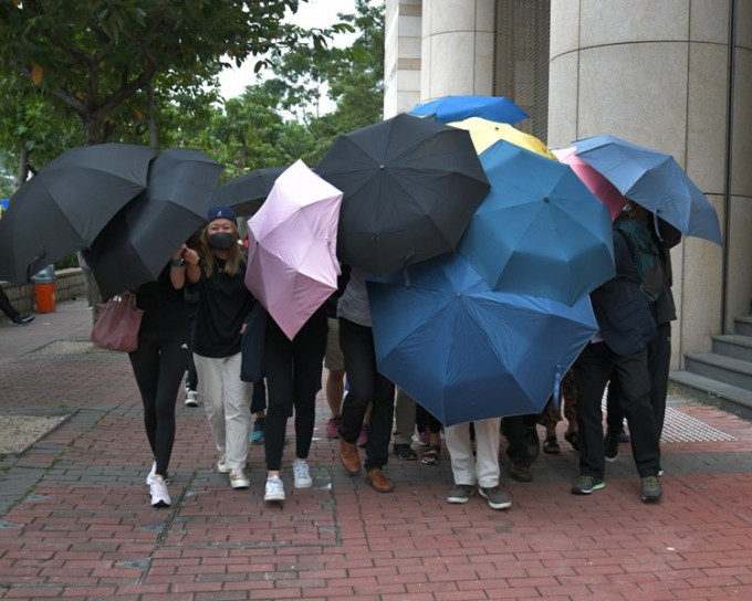 多名被告在雨傘遮掩下離開法庭。