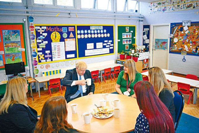 英国教师将获加薪百分五。图为首相约翰逊与幼儿园教师茶敍。