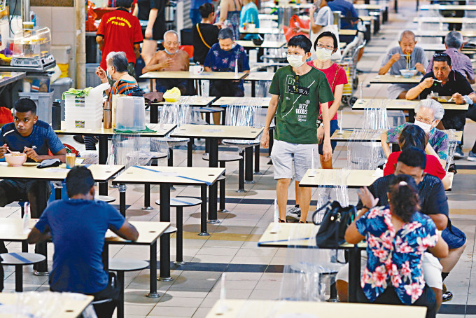 ■新加坡人周二在熟食中心用餐時保持社交距離。