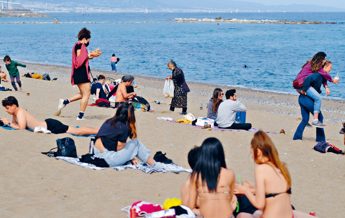 泳客在西班牙巴塞隆拿一個海灘曬太陽。