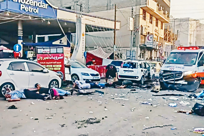 加沙城希法醫院門口一輛救護車上周五遭以軍空襲，死傷者倒在車旁。