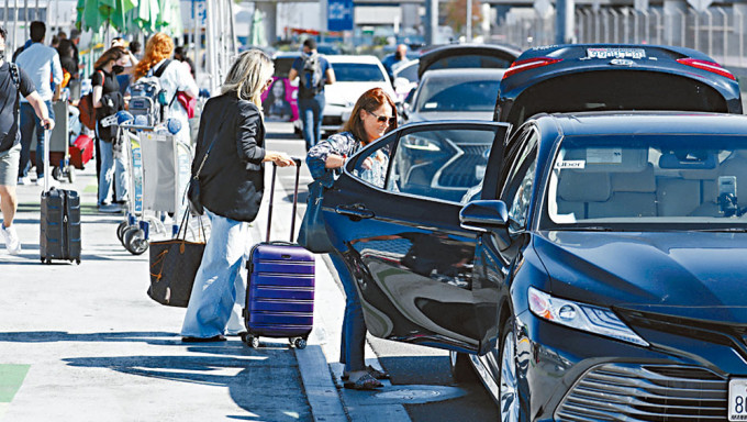 旅客在洛杉磯機場，乘搭Uber網約車。
