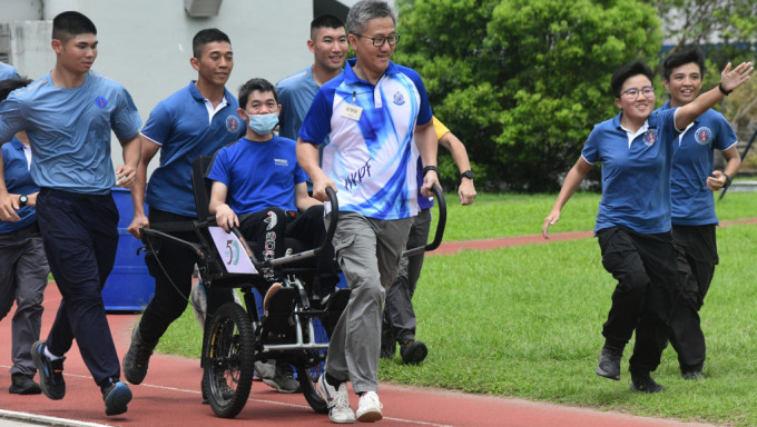 警务处处长萧泽颐参与「一起走过学堂的日子——轮椅人力车义工服务」活动，以特制的轮椅人力车接载受助人。梁国峰摄