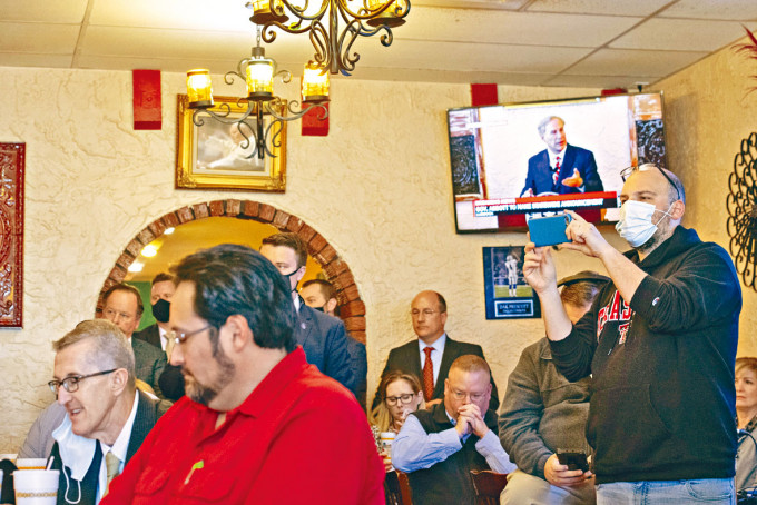 德州一家墨西哥餐厅的食客，收看州长阿伯特宣布解除口罩令。