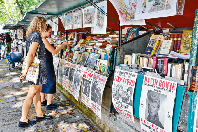 遊客上周六在塞納河畔的書攤，翻閱古董書和舊海報。