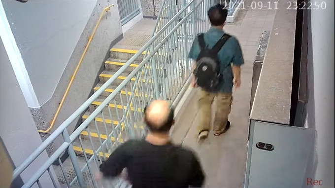 2名男子在走廊徘徊又观望一个单位。网民Ray Wong片段截图