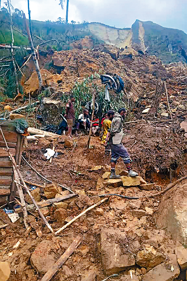 巴布亚新畿内亚一条村庄发生大规模山泥倾泻，救援人员周日在现场挖掘。