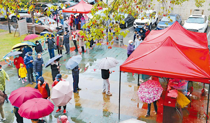 上海疫情惡化，民眾昨天冒雨排隊檢測。