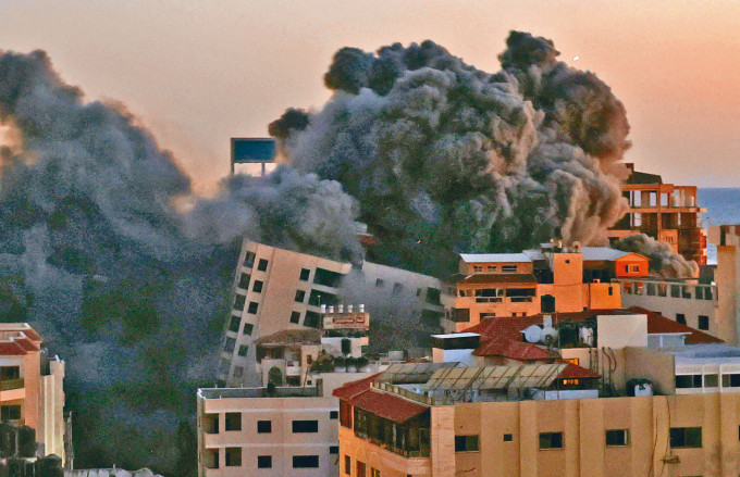 在哈马斯武装组织控制的加沙市，哈纳迪大楼周二遭以军空袭后冒出浓烟。
