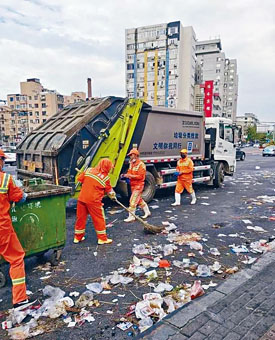 ■清洁工正在清扫大连夜市区域留下的垃圾。