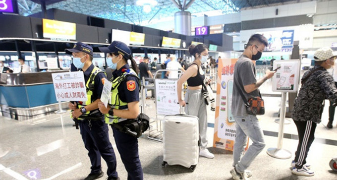 台湾警员在机场提醒到东南亚的旅客要小心海外打工陷阱。资料图片