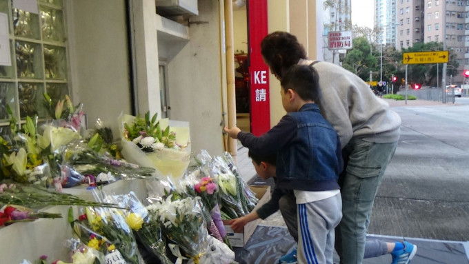 有市民带同儿子献花。黄文威摄